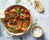 Aloo gobi curry with cauliflower and potatoes in a pot with bread
